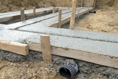 Drainagerohr und Schalung entlang eines Fundaments